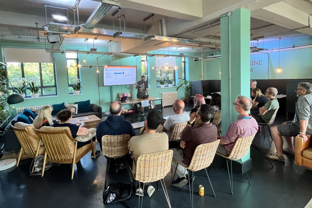 Simon talking at the WordPress Bristol meetup in front of a group of seated viewers